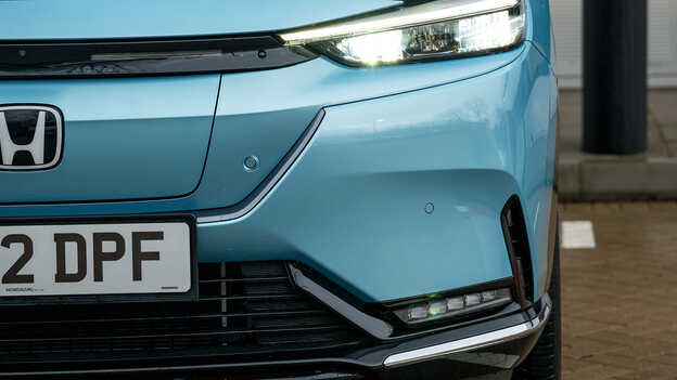 Nærbillede af den parkerede blå Honda e:Ny1-bil.