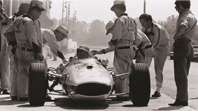 Honda Formel 1-bil fra 1960 med racerkører og ingeniører, set forfra.
