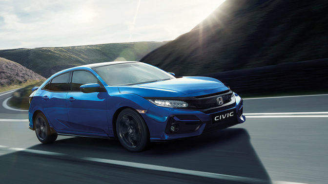 Honda Civic, der kører i en by, set skråt forfra.