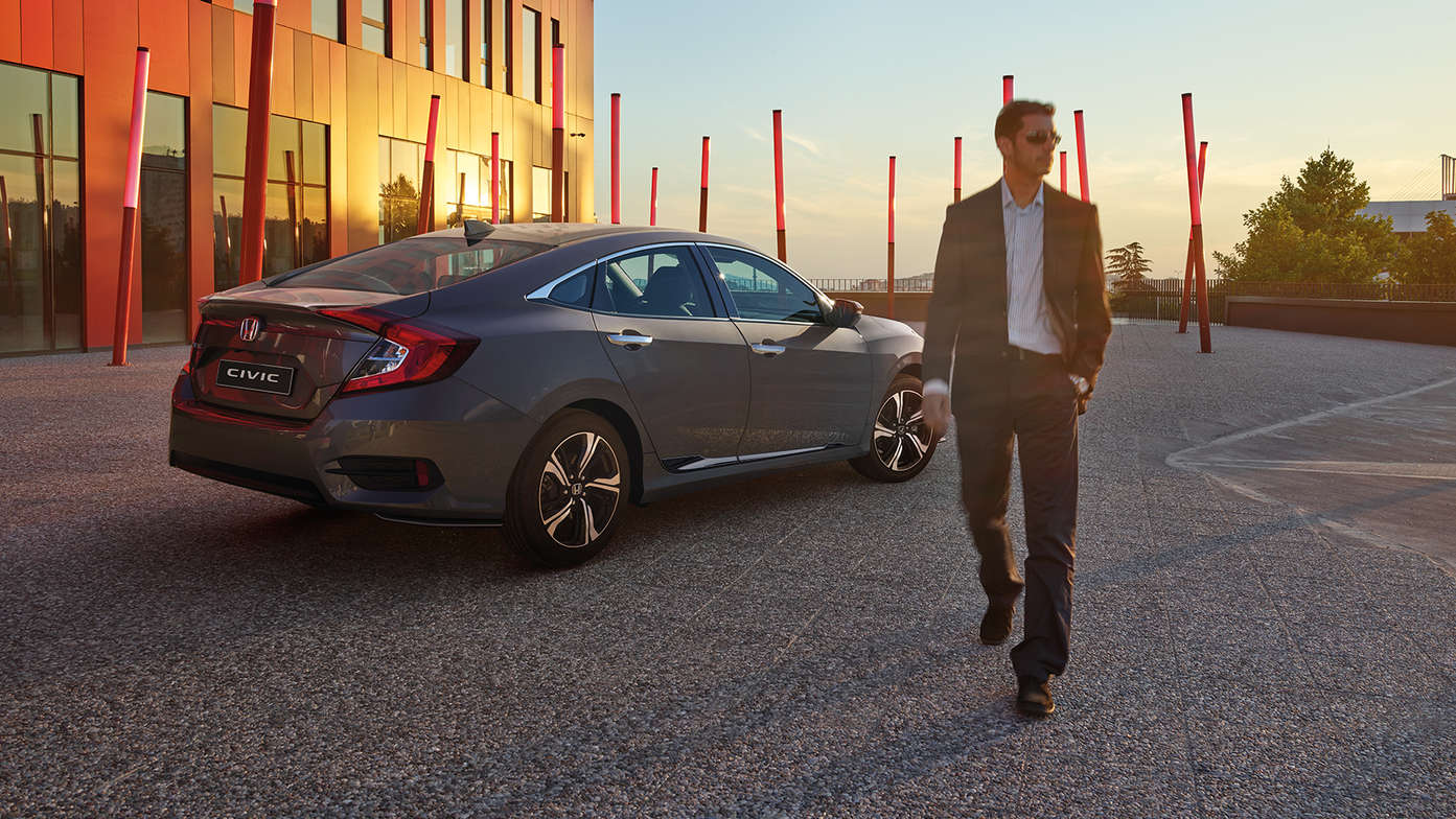 Honda Civic 4-dørs med fører, set skråt bagfra.