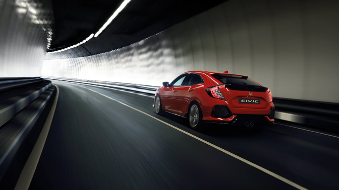 Honda Civic, som kører gennem en tunnel, set skråt bagfra.