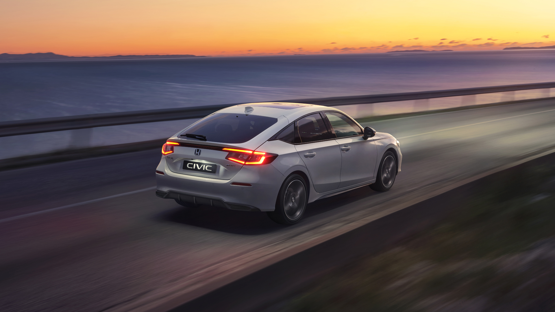 Civic Hybrid car driving in the sunset.