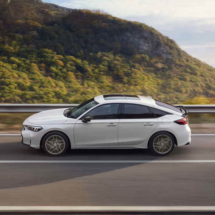 Honda Civic Hybrid i bevægelse på en motorvej med smuk udsigt.