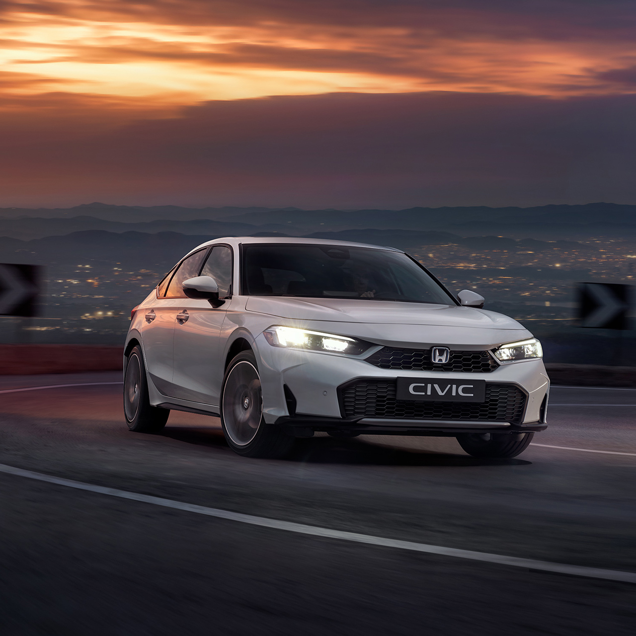 Honda Civic Hybrid i bevægelse på en motorvej i skumringen.