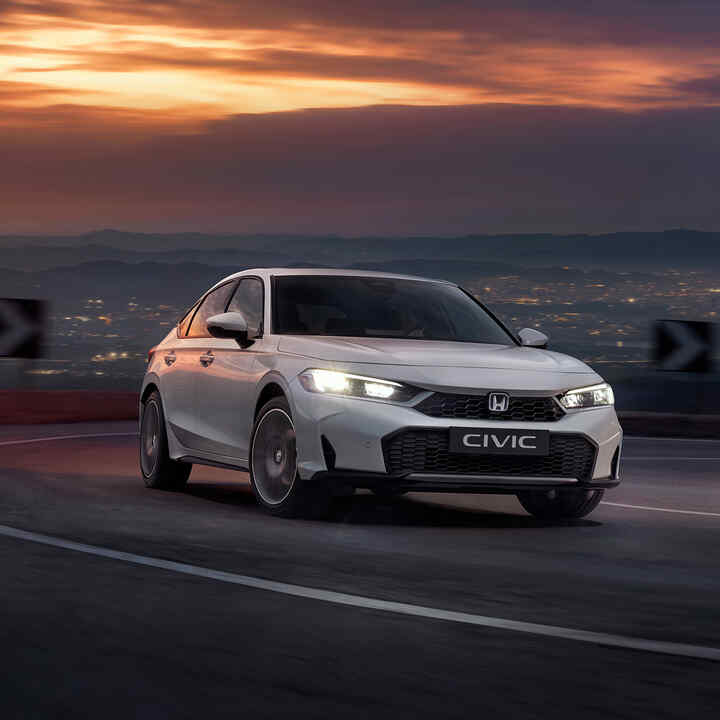 Honda Civic Hybrid i bevægelse på en motorvej i skumringen.