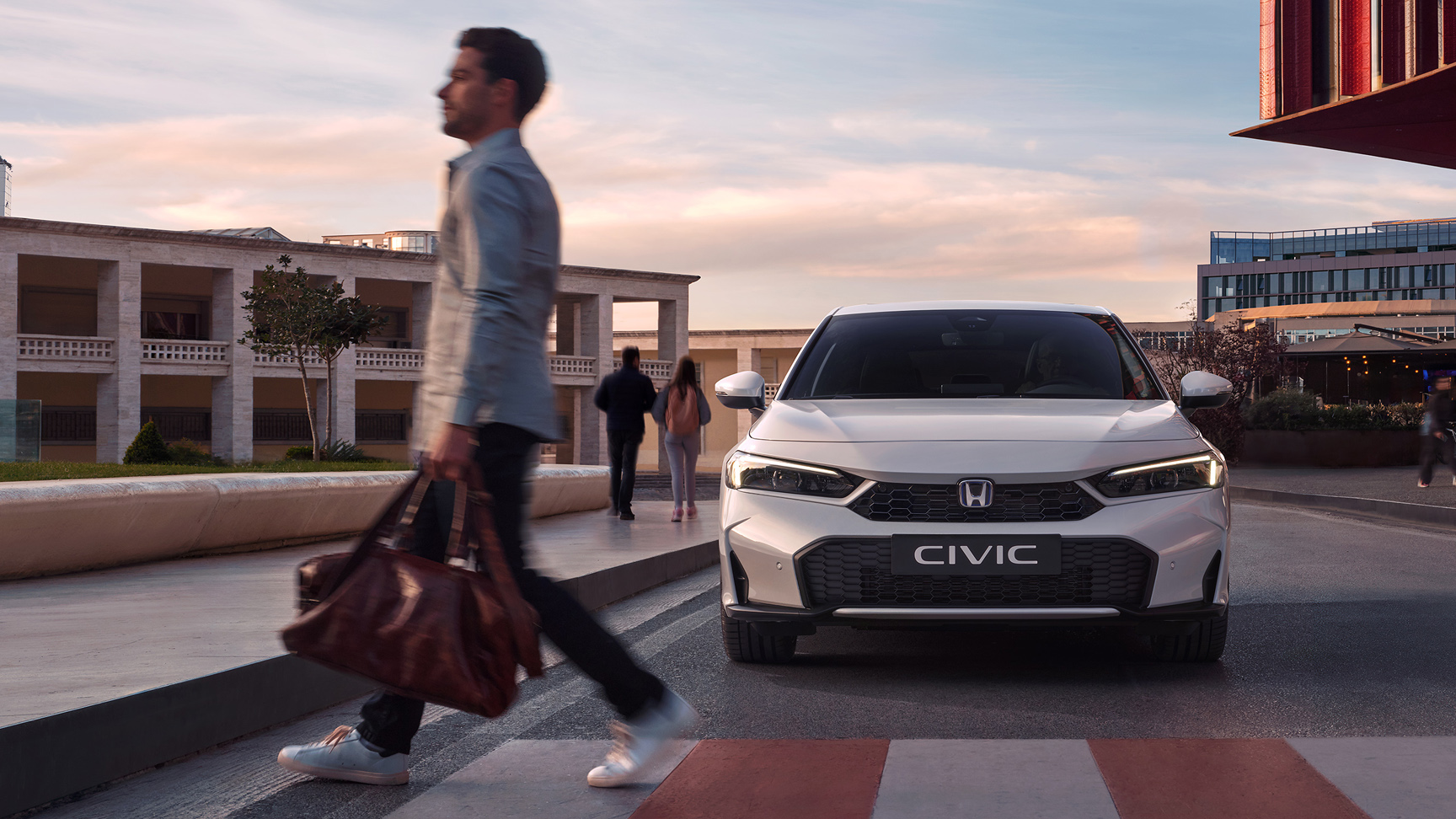 Honda Civic Hybrid nærmer sig en mand foran et fodgængerfelt.