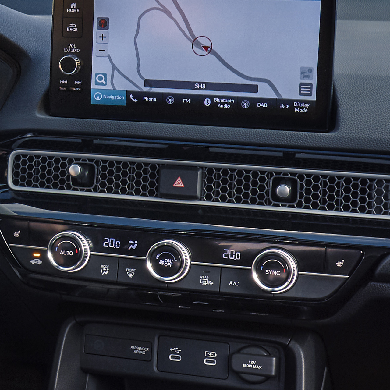 Foto taget fra kabinen af en Civic Hybrid, en mand kører på en naturskøn vej.