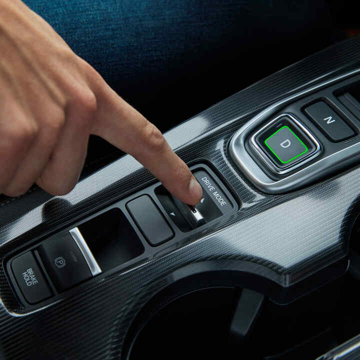 Nærbillede af en person, der skifter køretilstand i Civic Hybrid.