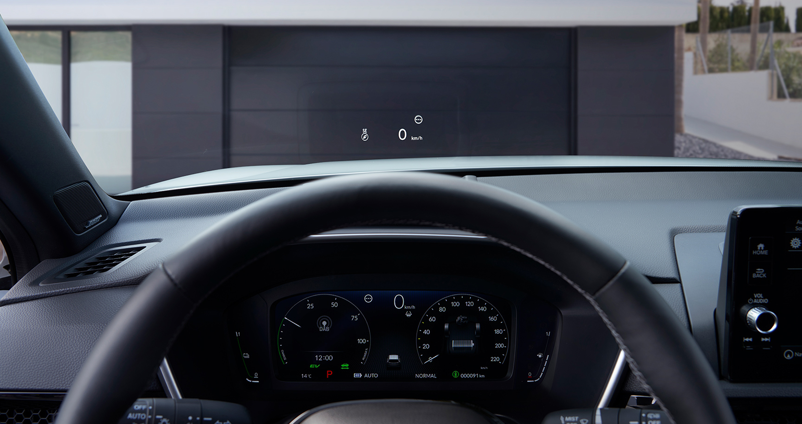 Fra førersædet ses et head-up-display (HUD), der projicerer "50 km/t" og et kompas på forruden over en grusvej.