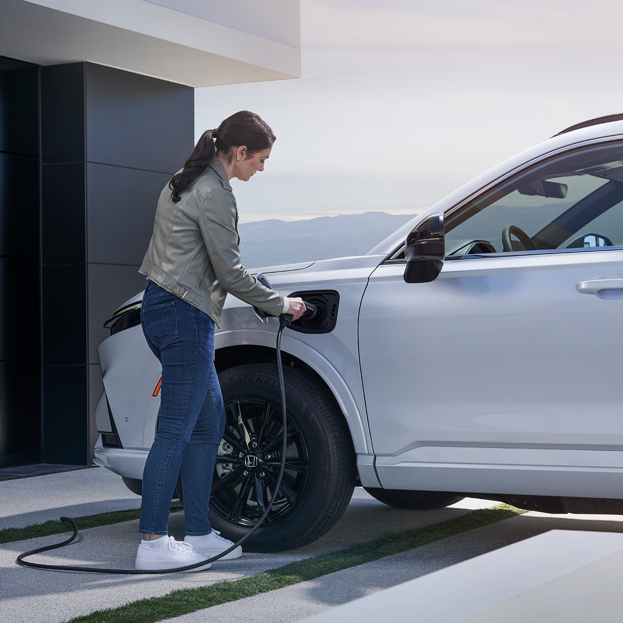 Honda CR-V Plug-in Hybrid SUV, der er sat til opladning, set skråt forfra.