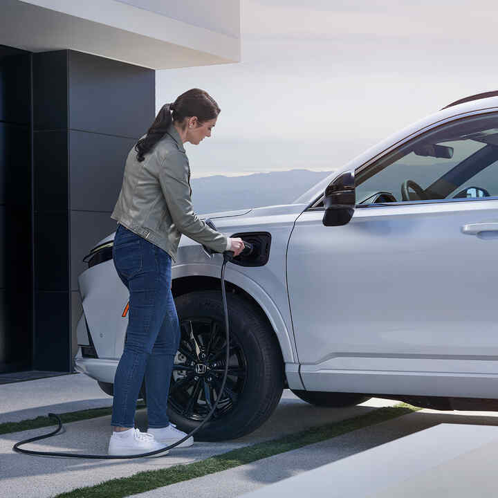Honda CR-V Plug-in Hybrid SUV, der er sat til opladning, set skråt forfra.