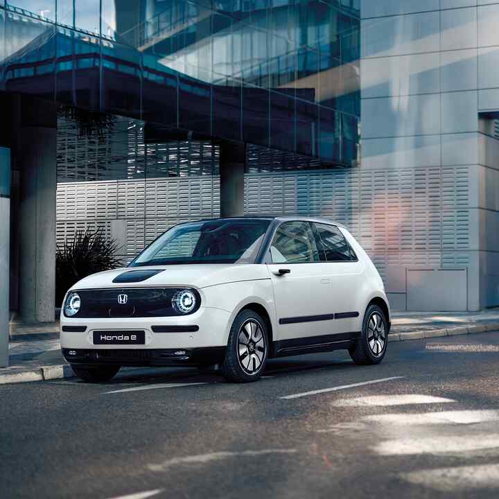 Honda e på gaden med bygninger i baggrunden