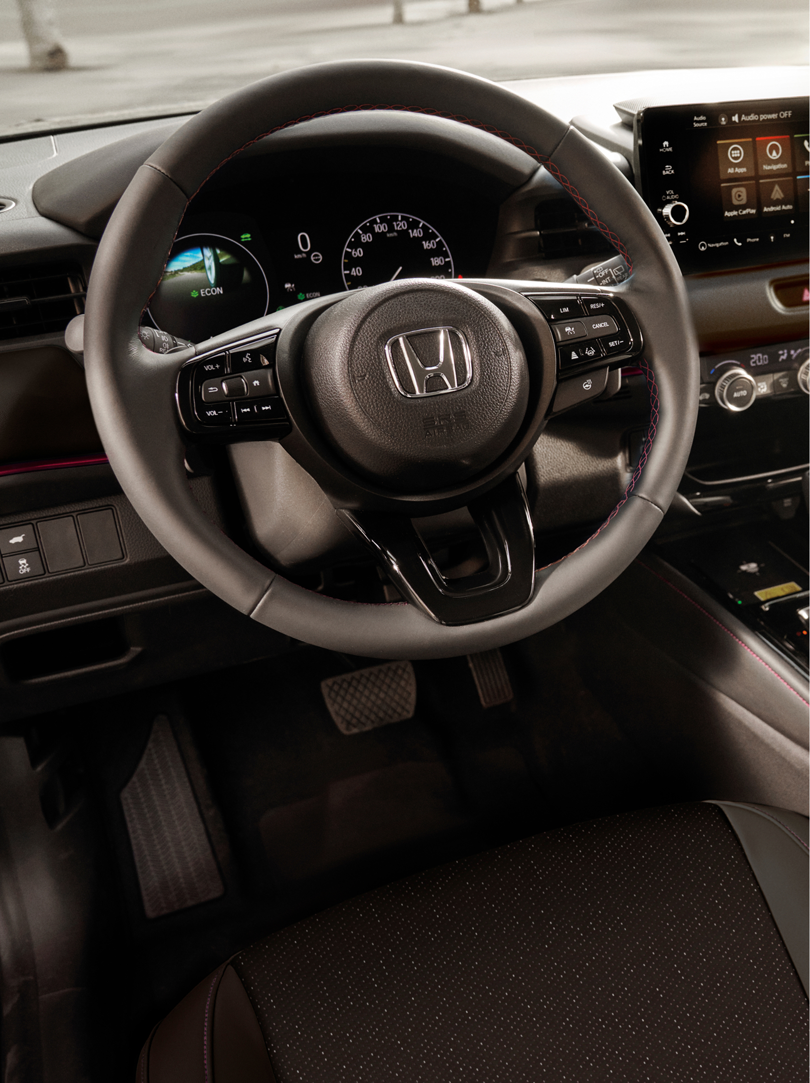 Interiørvisning af en Honda HR-V, der viser rattet, digitalt instrumentpanel, center-touchskærm og automatisk gearvælger.