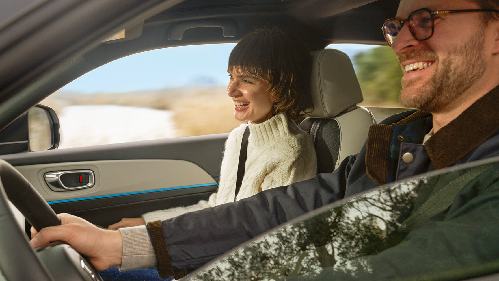 Par smiler, mens de er i en bil. 