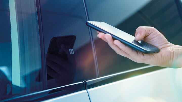 My Honda+ app nærbillede af en person, der bruger sin telefon uden for bilen