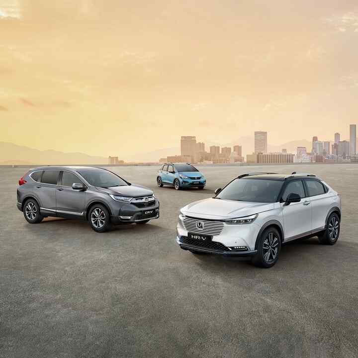 Parkerede Honda Hybrid-biler med storby i baggrunden