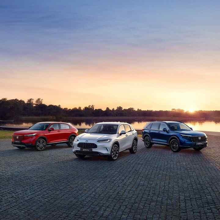 Parkerede Honda Hybrid-biler med storby i baggrunden