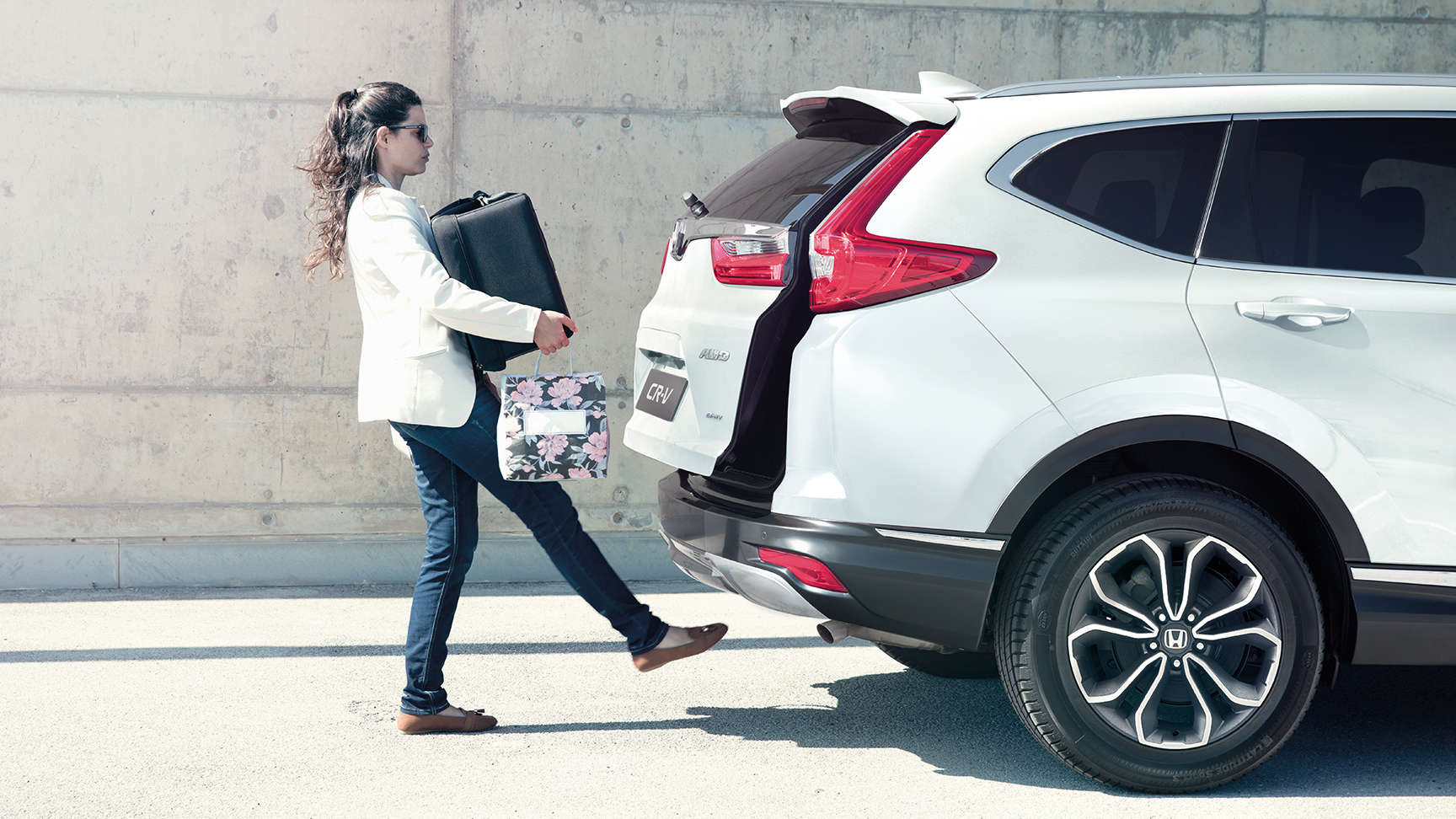 Kvinde sætter bagage i bagagerummet på CR-V