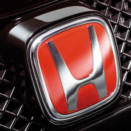 Nærbillede af rødt Honda H-logo.